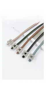 Detail view of five colors of thin cowhide leather belts with sparkling rhinestone buckles