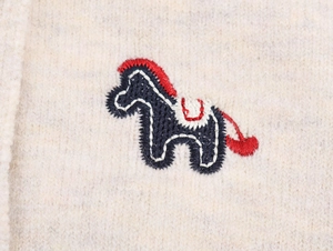 Detailed close-up of high-quality navy and red horse embroidery on beige knitted cardigan