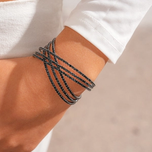 Detail of a multi-layer black crystal wrap bracelet on a model wrist with elegant finish