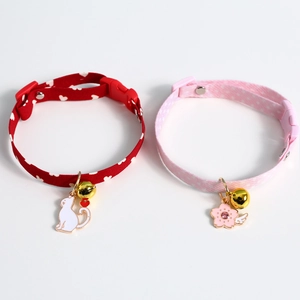 Detail of red heart and pink floral pet collars with gold bells and cute pendants
