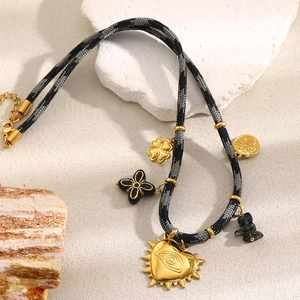 Détail du collier en corde tressée avec pendentif cœur œil en or 18K et trèfles