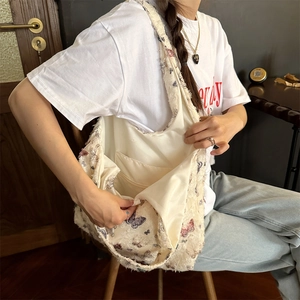 Detailed view of large butterfly print canvas tote bag with fringed edges and inner pocket