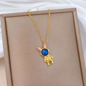 Makro-Detail der goldenen Astronauten-Hasen-Halskette mit rosa Ohren und blauem Glitzer