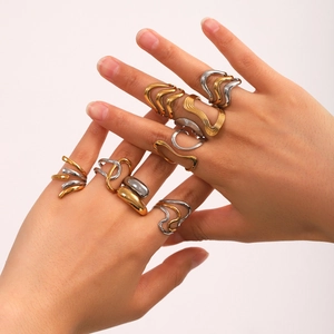 Detail showing stacked gold and silver wave-shaped geometric stainless steel rings
