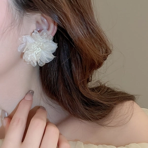 Close-up of white tulle flower earrings with beaded stamens on model for an elegant look