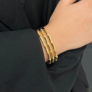 Close-up of three-piece 18K gold-plated stainless steel bamboo style open bangles for women