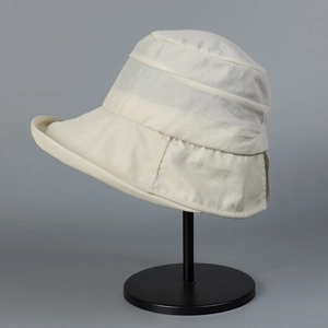 Detail of ivory nylon waterproof bucket hat showing layered crown and horizontal stitching