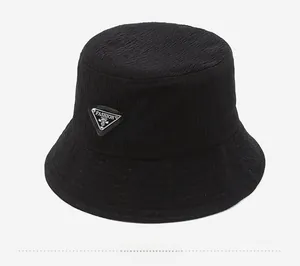 Detail of black bucket hat featuring textured waffle fabric and metal triangle logo