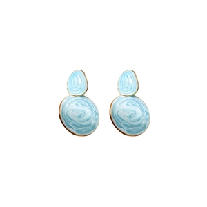 Close-up of light blue marble drip oil earrings with gold edges and oval texture
