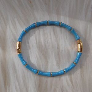 Bamboo style 18k gold plated bangle with sky blue enamel details on white faux fur
