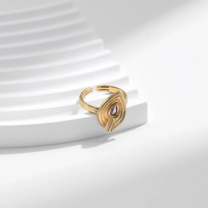 18K gold leaf ring featuring a teardrop purple zircon set on a white textured pedestal