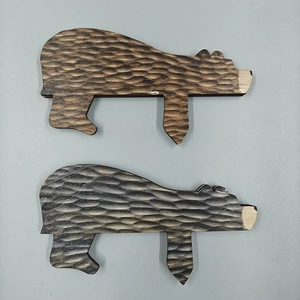 Macro shot of two hand-carved brown wooden bear sculptures with natural rustic texture