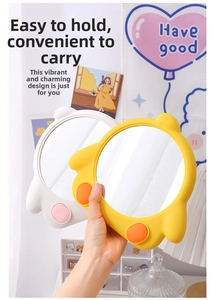 Detail showing the portable size of a cute cartoon chick makeup mirror in hand