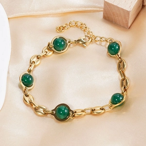 Vintage gold plated stainless steel bracelet with green emerald stones on silk