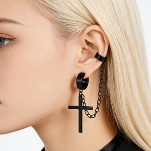 Macro shot of black stainless steel cross earring with chain connector on a model