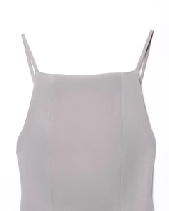 Close-up of gray backless pleated dress showing thin straps and fine fabric texture