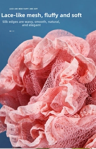 Macro detail of pink PE lace mesh bath ball with soft wavy edges on blue background