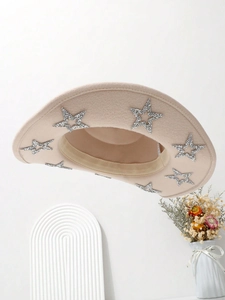 Detail of beige cowboy hat brim featuring shiny silver sequin star embellishments