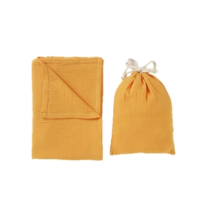 Double-layer cotton muslin baby blanket with matching drawstring storage bag in ginger yellow