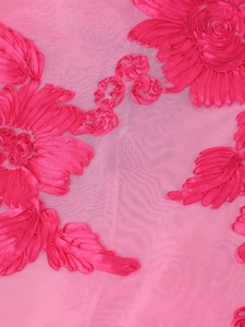 Detail of pink mesh fabric with 3D floral embroidery and fine mesh texture close-up