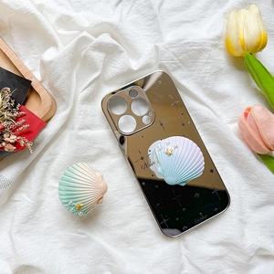 Detail of gradient seashell phone case with 3D star and pearl elements on white fabric