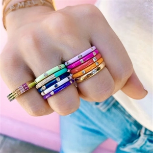 Close-up of stacked colorful enamel rings with cubic zirconia on a female model hand