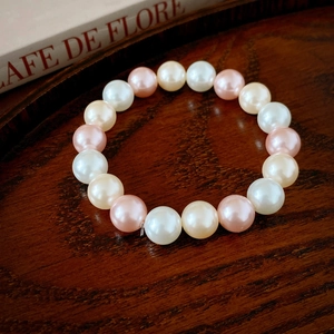 Vue détaillée du bracelet de perles rétro français sur un plateau élégant en bois sombre