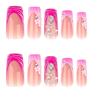 Pink zebra pattern press-on nails with 3D floral accents and heart charms on white background