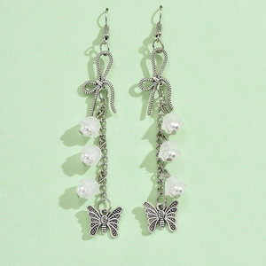 Detail of silver long drop earrings with white flower petals and butterfly charms