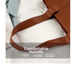 Close-up of brown faux leather tote bag showing fine stitching and textured handle