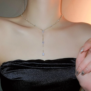 On-model view of a gold Y-shaped necklace with sparkling zircon drop tassel detail