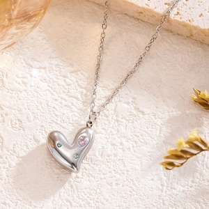 Silver titanium steel necklace with pink heart zircon pendant on white stone base