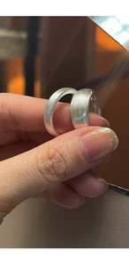 Close-up of matte brushed S925 silver rings showing detailed metal texture on finger