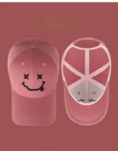 Détail de la casquette de baseball en coton rose avec broderie smiley et vue intérieure