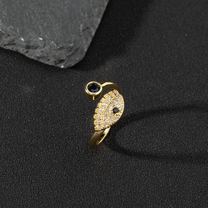 Macro shot of copper zircon evil eye ring with blue stones and leaf detail on dark stone
