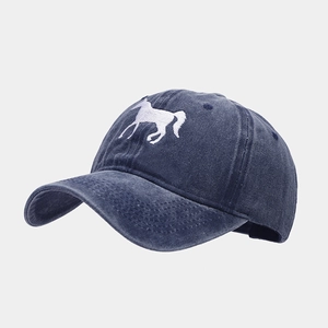 Close-up of white horse embroidery on washed cotton navy blue baseball cap