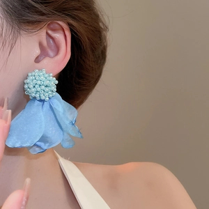 Detail of blue fabric flower earrings with beaded cluster and layered tulle petals