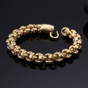 Macro detail of golden stainless steel skull links and polished clasp on the bracelet