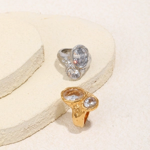 Detailed macro view of 18K gold plated rings with dual zircons and irregular rock texture