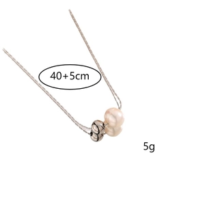 Detailed view of titanium steel necklace with pink pearl pendant and polished metal bead