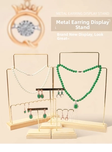 Detailed view of golden metal jewelry stand set with natural wooden base for earrings