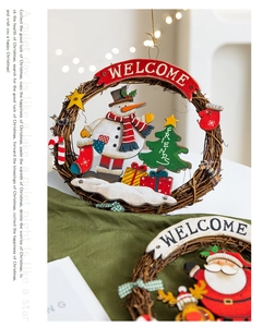 Close-up of Christmas wreath with wooden snowman, gifts and Welcome sign decoration