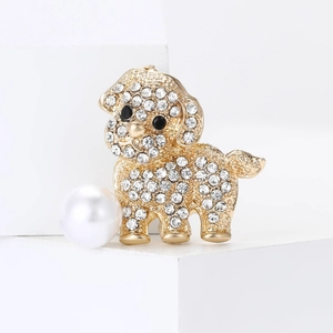 Fashionable golden dog brooch with sparkling rhinestones and a white pearl on white pedestal