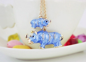 Detailed close-up of blue enamel rhino charms with gold plating and sparkling rhinestones