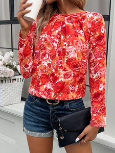 Detail of red floral long sleeve top with crew neck and stylish pleated front design