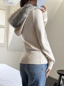 Detailed back view of a beige knit hoodie with faux fur trim hood and ribbed cuffs