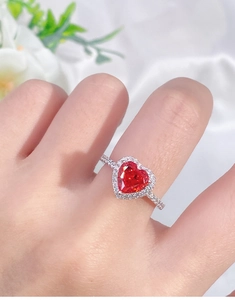 Detailed view of halo setting red heart-shaped gemstone ring with pave diamonds