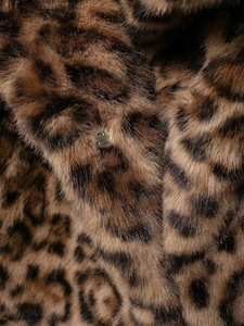 Macro detail of faux leopard fur texture with realistic brown and black plush fibers