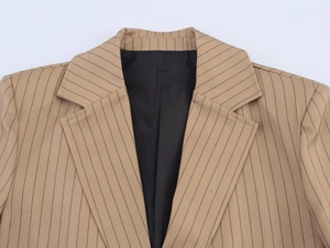 Detail of khaki striped linen-blend blazer neckline and structured shoulder tailoring