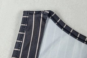 Macro shot of striped knit fabric detailing precise double-needle hem stitching